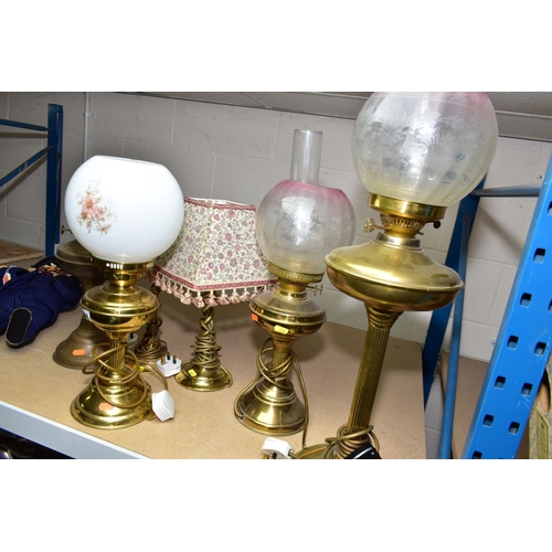 666 - A GROUP OF SIX BRASS TABLE LAMPS, including three converted to electric oil lamps, with glass shades... 