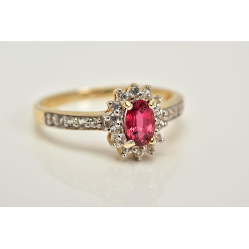 76 - A 9CT GOLD RUBY AND SAPPHIRE CLUSTER RING, designed with a central oval cut ruby within a circular c... 