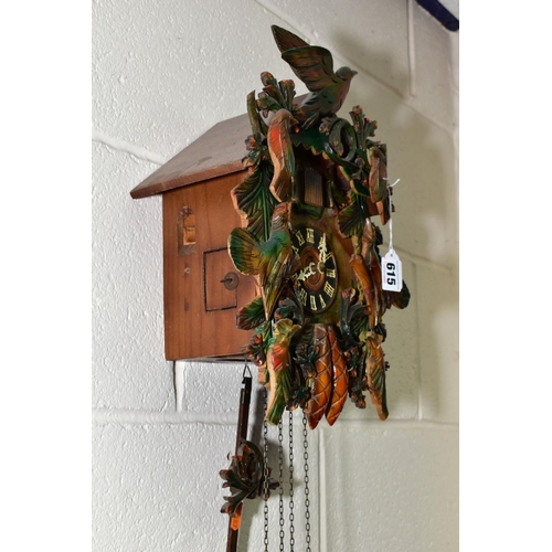 615 - A MID TWENTIETH CENTURY cuckoo clock with pendulum and weights, height approximately 33cm