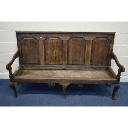 1290 - A DISTRESSED GEORGIAN OAK HALL SETTLE, having four fielded panels, swept armrests, on triple cabriol... 