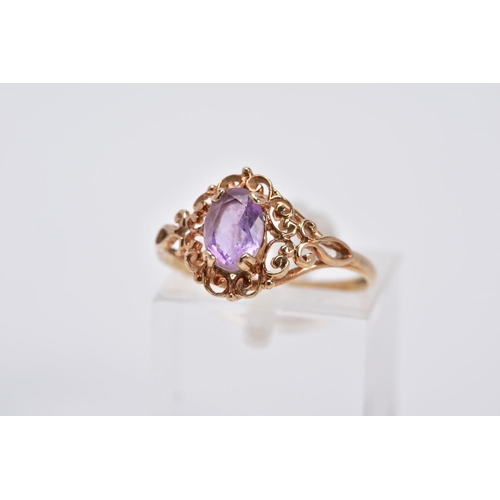 36 - A 9CT GOLD AMETHYST RING, designed with a claw set, oval cut amethyst, within an openwork scroll det... 