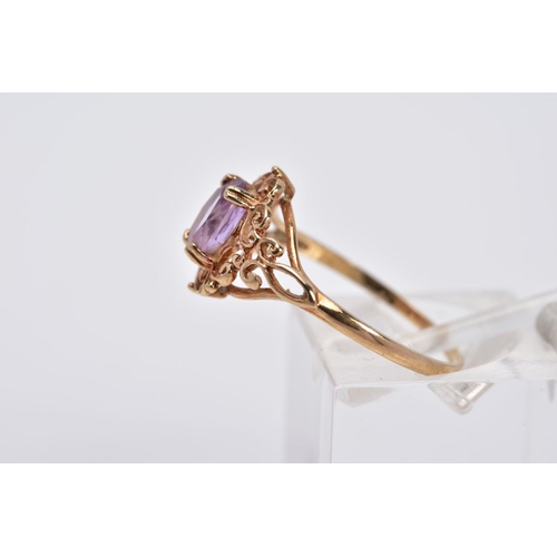 36 - A 9CT GOLD AMETHYST RING, designed with a claw set, oval cut amethyst, within an openwork scroll det... 