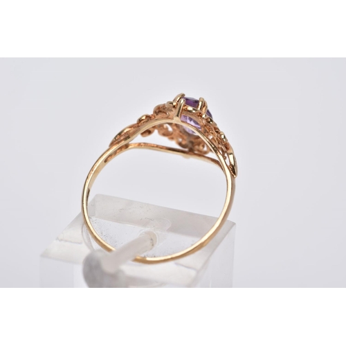 36 - A 9CT GOLD AMETHYST RING, designed with a claw set, oval cut amethyst, within an openwork scroll det... 