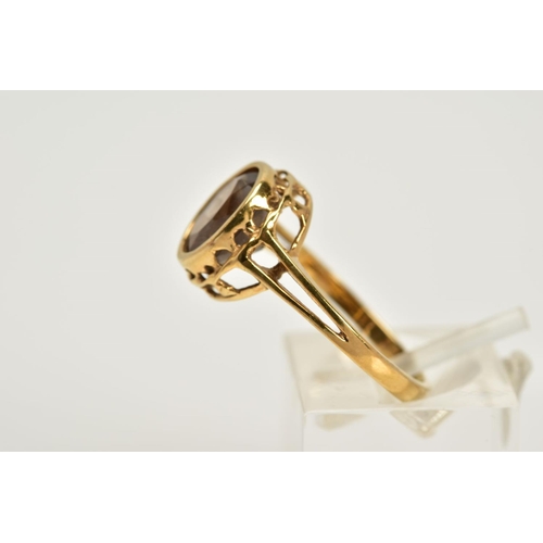 52 - A 9CT GOLD SMOKEY QUARTZ RING, designed with an oval cut smokey quartz within a collet mount, openwo... 