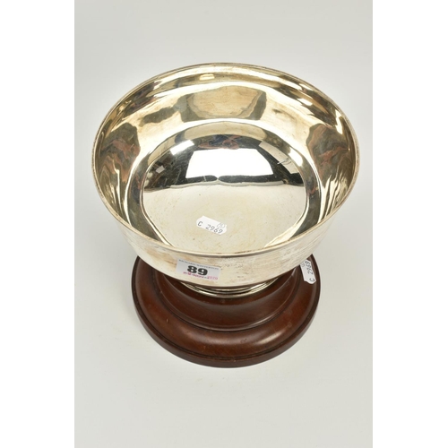 89 - A SILVER BOWL ON A WOODEN BASE, a plain polished bowl with a raised bottom, hallmarked Chester 1919,... 