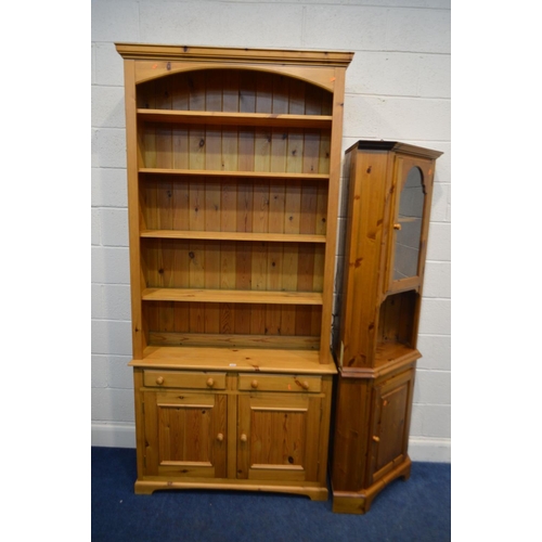 1332 - A TALL PINE OPEN BOOKCASE, with four fixed shelves, above two drawers and double cupboard doors, wid... 