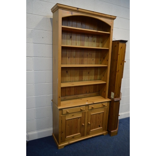 1332 - A TALL PINE OPEN BOOKCASE, with four fixed shelves, above two drawers and double cupboard doors, wid... 