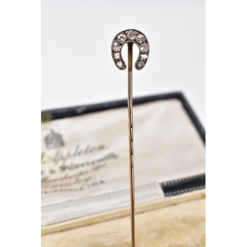 18 - AN EDWARDIAN DIAMOND STICK PIN, the yellow metal pin in the form of a horse shoe, set with five old ... 