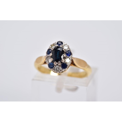 21 - A SAPPHIRE AND DIAMOND CLUSTER RING, of tiered design set with a central oval cut sapphire, within a... 