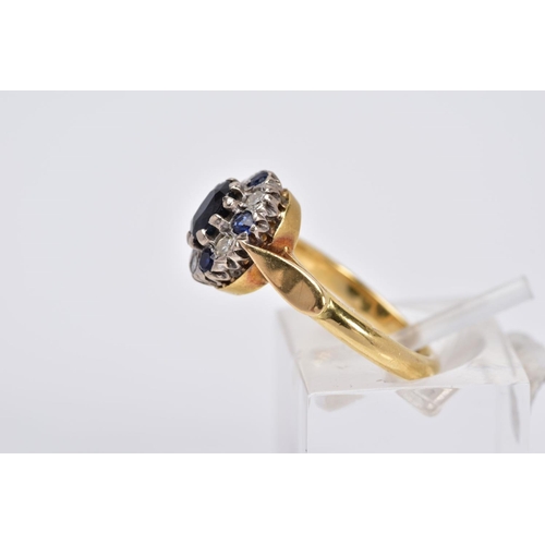 21 - A SAPPHIRE AND DIAMOND CLUSTER RING, of tiered design set with a central oval cut sapphire, within a... 