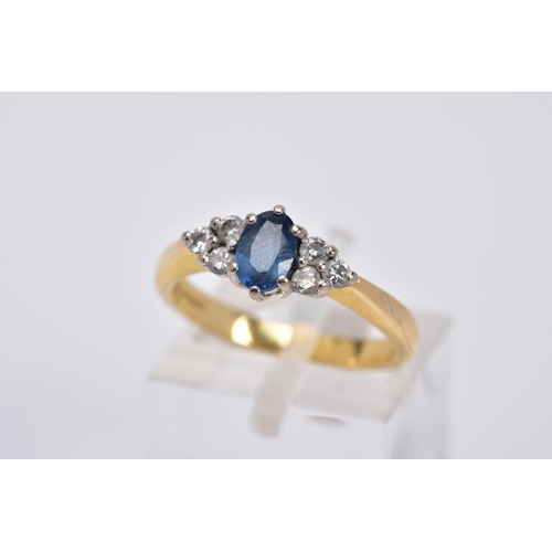 24 - AN 18CT GOLD SAPPHIRE AND DIAMOND RING, designed with a central oval cut sapphire flanked by three r... 