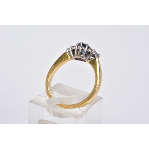 24 - AN 18CT GOLD SAPPHIRE AND DIAMOND RING, designed with a central oval cut sapphire flanked by three r... 