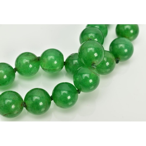 103 - A JADE BEADED NECKLACE, dyed green circular beads, on a green cord, each bead measuring approximatel... 