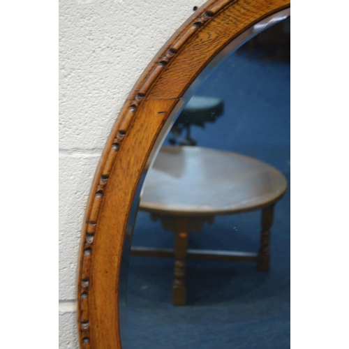 1240 - AN EARLY TO MID 20TH CENTURY OAK OVAL BEVELLED EDGE WALL MIRROR, 97cm x 72cm