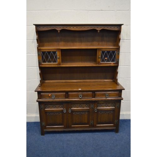 1243 - AN OLD CHARM OAK DRESSER with a central shelf to top, flanked by lead glazed cupboard doors abovve t... 