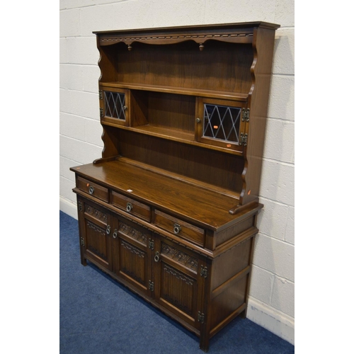 1243 - AN OLD CHARM OAK DRESSER with a central shelf to top, flanked by lead glazed cupboard doors abovve t... 