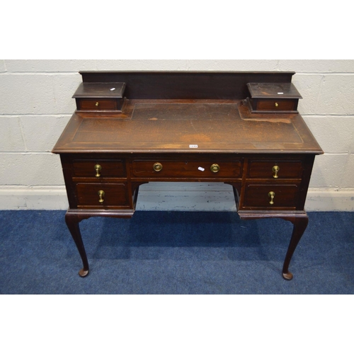 1249 - AN EDWARDIAN MAHOGANY LADIES DESK, with a brown leatherette top and seven various drawers, on cabrio... 