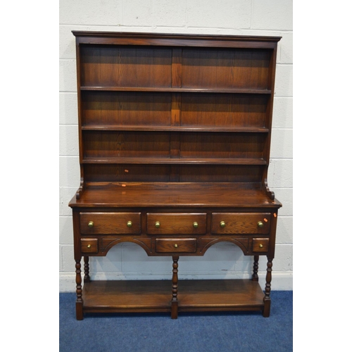 1252 - A REPRODUCTION OAK DRESSER, with a three tier plate rack above a base with six various drawers, on t... 