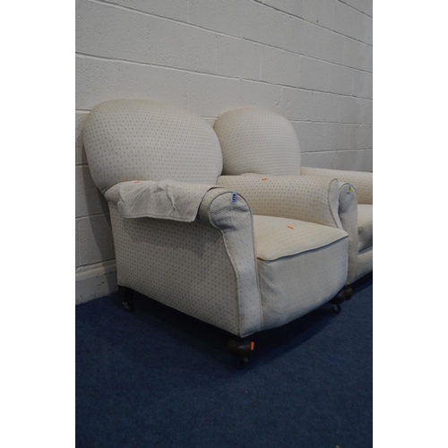 1274 - IN THE MANNER OF HOWARD AND SONS, a pair of early 20th Century cream upholstered armchairs, on bun f... 