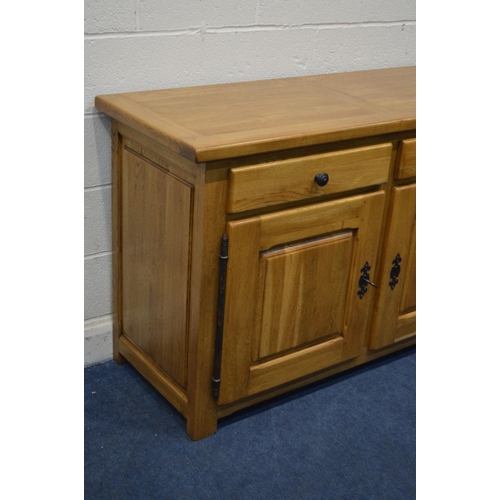 1335 - A SOLID GOLDEN OAK SIDEBOARD, with two drawers above double fielded panel cupboard doors, width 141c... 