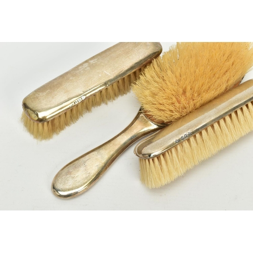 177 - A THREE PIECE EDWARDIAN SILVER VANITY SET, to include a hair brush and two clothes brushes, each of ... 