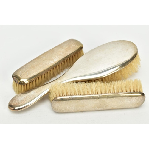 177 - A THREE PIECE EDWARDIAN SILVER VANITY SET, to include a hair brush and two clothes brushes, each of ... 