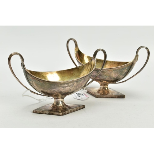 188 - A NEAR PAIR OF GEORGE III STERLING SILVER SALTS, each twin handled oval urn form on a raised lozenge... 