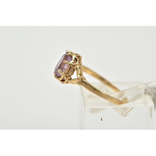 39 - A 9CT GOLD AMETHYST RING, designed with a claw set, oval cut amethyst within an open work gallery, b... 