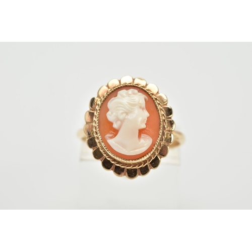 4 - A YELLOW METAL CAMEO RING, the cameo of oval design depicting a lady in profile, within a collet mou... 