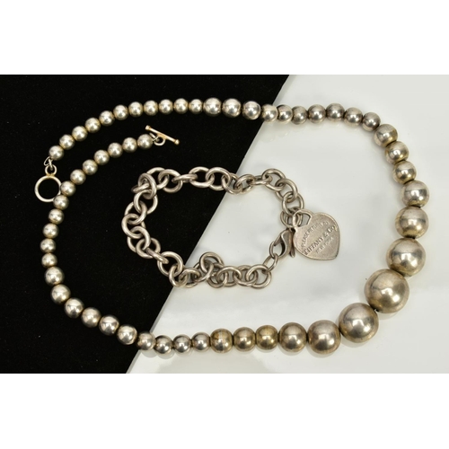 40 - A WHITE METAL BALL NECKLACE AND CHARM BRACELET, the necklace designed as plain polished graduated ba... 