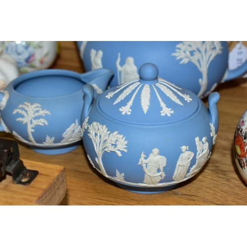 526 - A WEDGWOOD BLUE JASPERWARE THREE PIECE TEA SERVICE, comprising teapot, covered sugar bowl and milk j... 