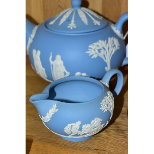 526 - A WEDGWOOD BLUE JASPERWARE THREE PIECE TEA SERVICE, comprising teapot, covered sugar bowl and milk j... 