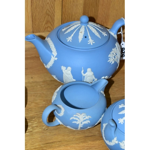 526 - A WEDGWOOD BLUE JASPERWARE THREE PIECE TEA SERVICE, comprising teapot, covered sugar bowl and milk j... 