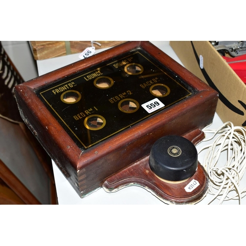 559 - A WOODEN CASED WALL MOUNTED SERVANTS BELL CALL BOX, black glass lidded box with six circular clear a... 