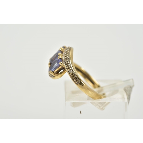 59 - A THREE STONE CROSS OVER RING, designed with three oval cut iolite, within single cut diamond detail... 