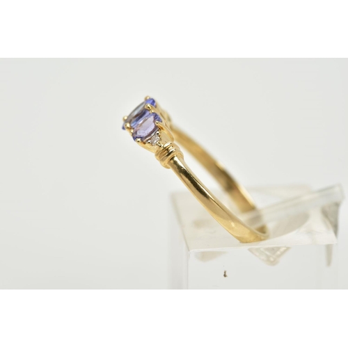 61 - A 14CT GOLD THREE STONE TANZANITE RING, designed with three graduated, oval cut tanzanite stones, fl... 