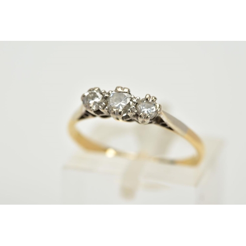 63 - A THREE STONE DIAMOND RING, the yellow metal ring, set with three graduated round brilliant cut diam... 