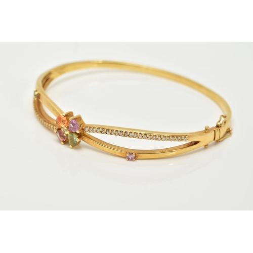 70 - A YELLOW METAL TOPAZ AND DIAMOND BANGLE, the openwork cross over style hinged bangle, set with a cen... 