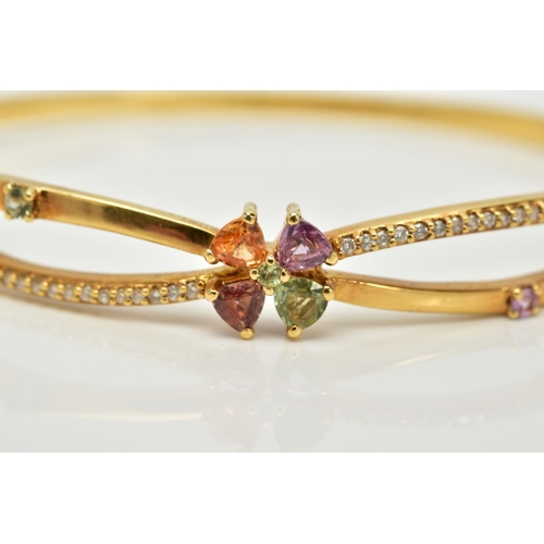 70 - A YELLOW METAL TOPAZ AND DIAMOND BANGLE, the openwork cross over style hinged bangle, set with a cen... 