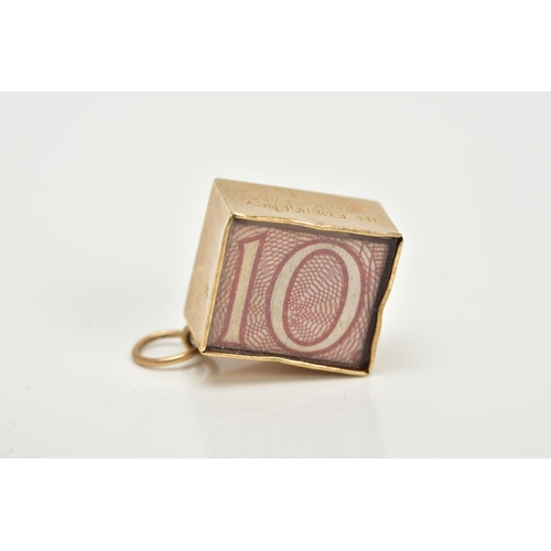 8 - A 9CT GOLD CASED TEN SHILLING NOTE CHARM, the folded note within a plain polished square case and gl... 