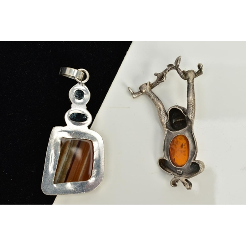 99 - TWO WHITE METAL PENDANTS, the first in the form of a monkey hanging from a tree branch, set with an ... 