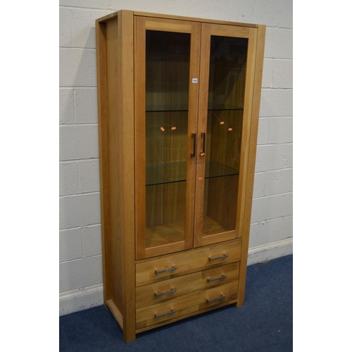 1341 - A MODERN GOLDEN OAK GLAZED TWO DOOR DISPLAY CABINET, two glass shelves above three drawers, width 90... 