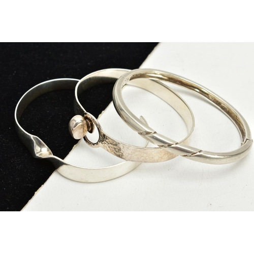 50 - THREE SILVER BANGLES, the first a twist cuff hallmarked London, together with a silver hinged bangle... 