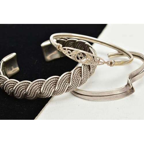 55 - A SILVER CUFF AND TWO WHITE METAL BANGLES, a twist designed cuff hallmarked Birmingham, approximate ... 