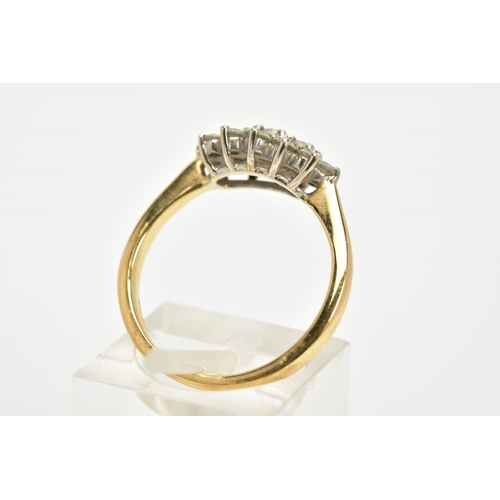 63 - AN 18CT GOLD DIAMOND CLUSTER RING, the cluster of an oval form, set with fifteen graduated round bri... 