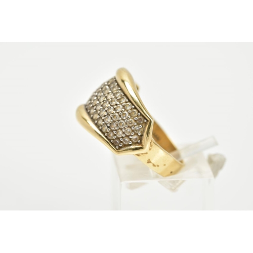 66 - A YELLOW METAL DRESS RING, designed as a slightly curved panel set with colourless stones assessed a... 