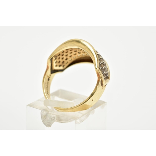 66 - A YELLOW METAL DRESS RING, designed as a slightly curved panel set with colourless stones assessed a... 