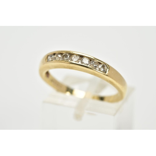 70 - A YELLOW METAL DIAMOND HALF ETERNITY RING, designed with a row of channel set round brilliant cut di... 