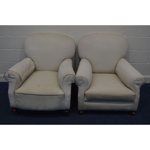 1352 - IN THE MANNER OF HOWARD AND SONS, a pair of early 20th Century cream upholstered armchairs, on bun f... 