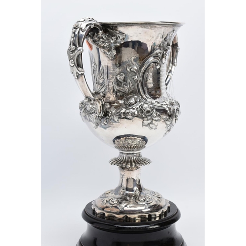 25 - A SILVER TROPHY CUP WITH STAND, the double handled trophy cup of a foliate and scroll detailed desig... 